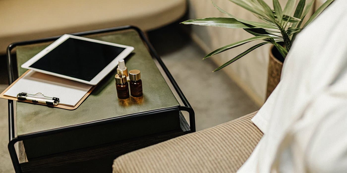 A tablet, chart, and wellness serums on a table in a calm consultation room