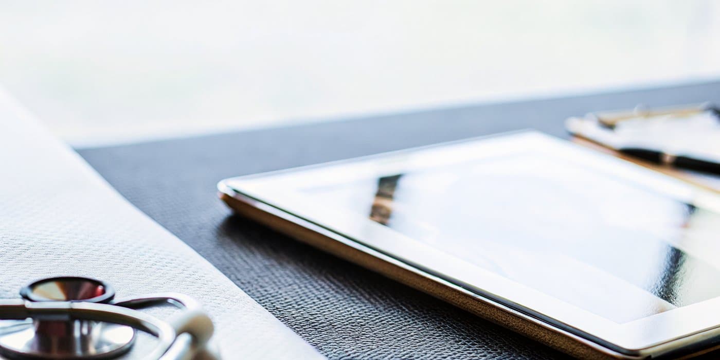 A clinician's tablet and stethoscope on the desk during a weight-loss progress review